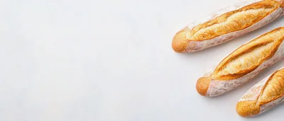 Three Freshly Baked French Baguettes On White Background