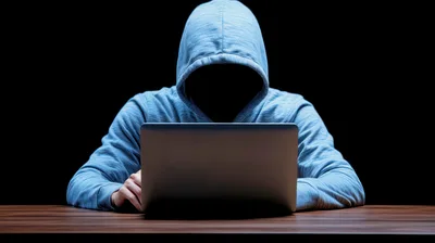 Anonymous Hacker Working On A Laptop In The Dark