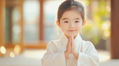 Young Asian Girl Bowing in Traditional White Karate Gi