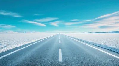 Empty Asphalt Road Through Vast Snowy Landscape