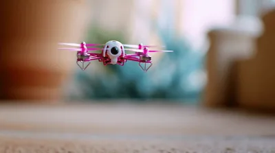 Small Pink Quadcopter Drone Hovering Indoors