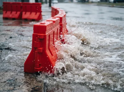 Water Splashing Against Red Plastic Road Barriers
