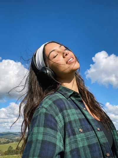 Young Woman Listening To Music Outdoors