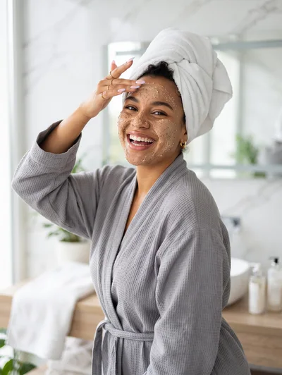 Happy Woman Applying Facial Scrub in Bathroom