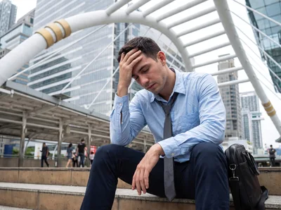 Stressed Businessman Sitting On City Stairs
