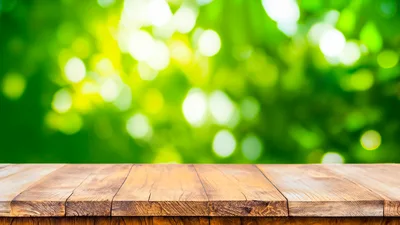 Empty Wooden Table Against Blurred Green Nature Background