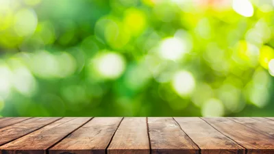 Empty Wooden Table Against Blurred Green Nature Background