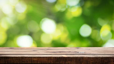 Empty Wooden Table Against Blurred Green Nature Background