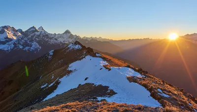 Sunrise Over Snow Capped Mountain Peaks