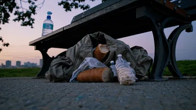 Baguette And Water Bottles Under A Park Bench