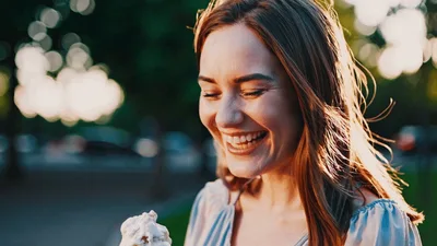 Happy Young Woman Eating Ice Cream Outdoors