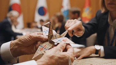 Diplomats Folding Paper Cranes During International Conference Meeting