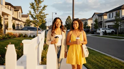 Two Women Walking And Talking In A Suburban Neighborhood