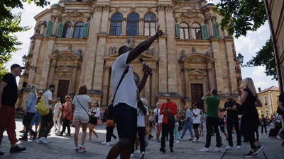 Tour Guide Speaking To Group In Front Of Cathedral