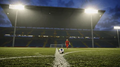 Soccer Player Running Toward Ball On Stadium Pitch