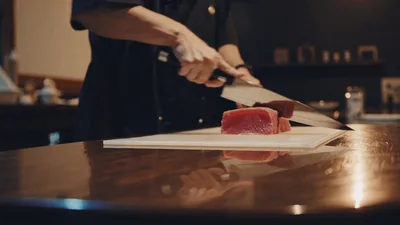 Professional Sushi Chef Slicing Fresh Tuna Fillet
