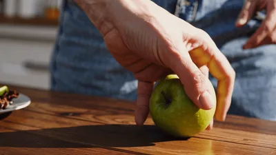 Hand Picking Up A Fresh Green Apple