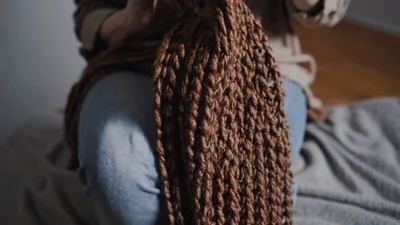 Woman Knitting Brown Wool Scarf With Crochet Hook