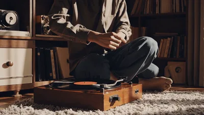 Person Placing Needle On A Vintage Vinyl Record Player