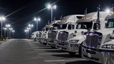 White Semi Trucks Parked In A Row At Night