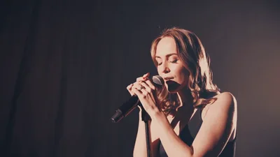 Female Singer Performing With Microphone On Stage
