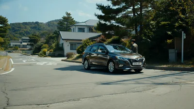 Man Walking Toward A Brown Station Wagon