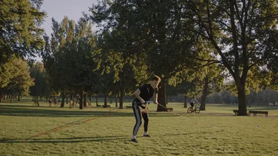 Young Man Performing Resistance Band Exercises In Park