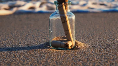 Message In A Bottle Resting On Sandy Beach