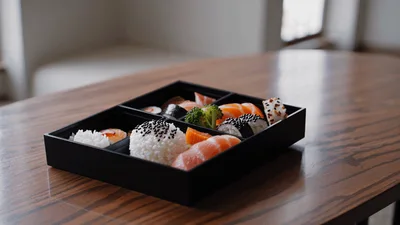 Bento Box With Sushi And Rice On Wooden Table