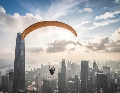 Paraglider Soaring Over City
