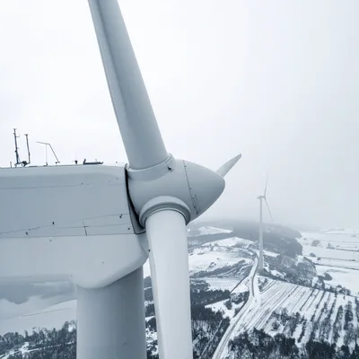 Aerial View Of Wind Turbines In Snowy Landscape