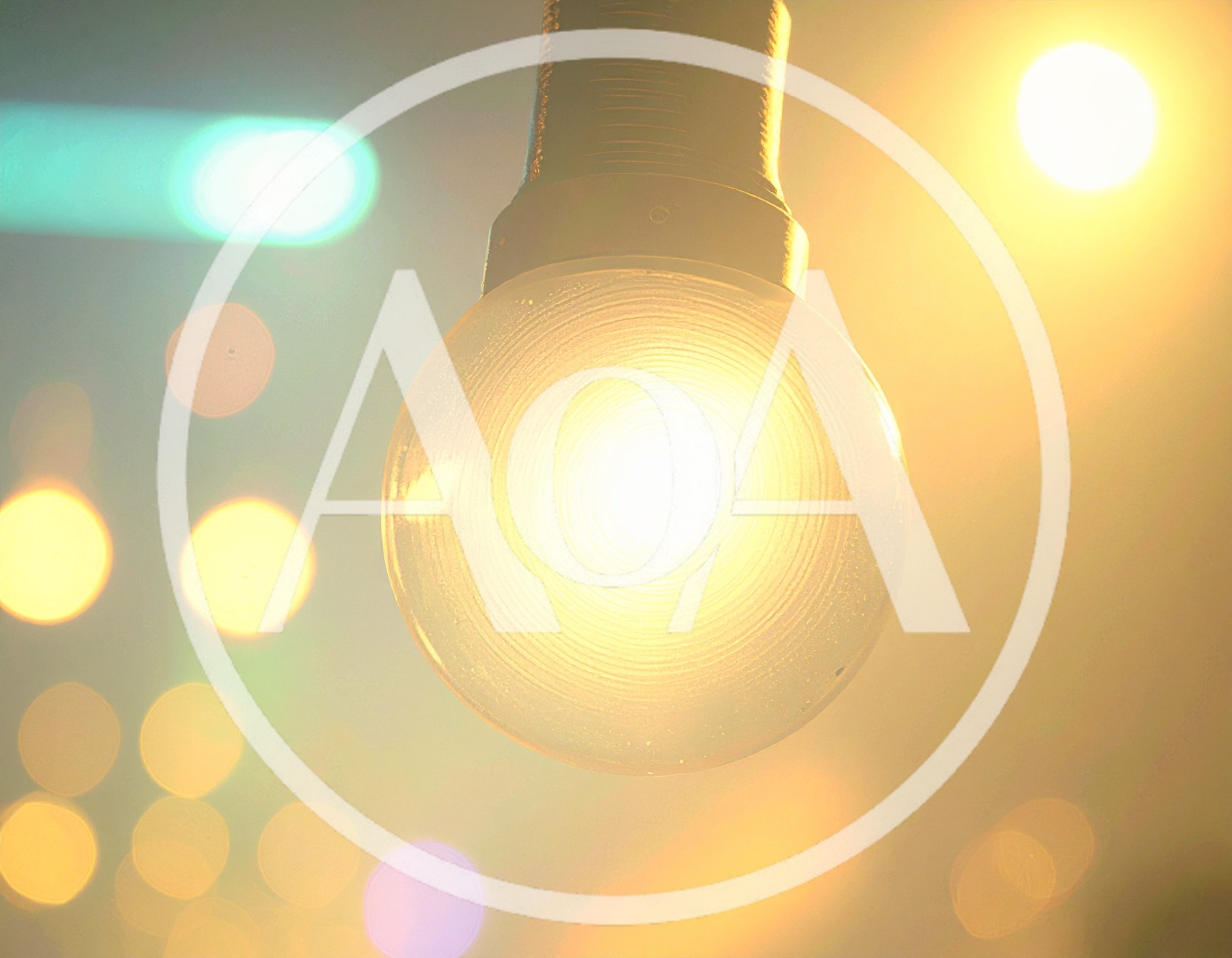 Glowing Incandescent Light Bulb Against Blurred City Lights