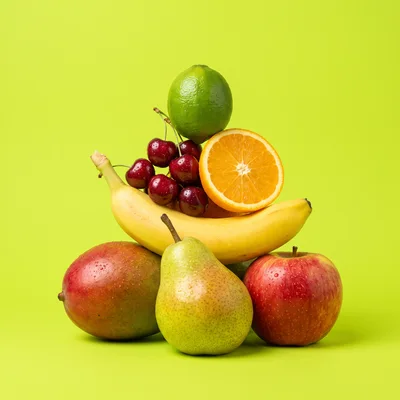 Assorted Fresh Fruits Stacked on Lime Green Background