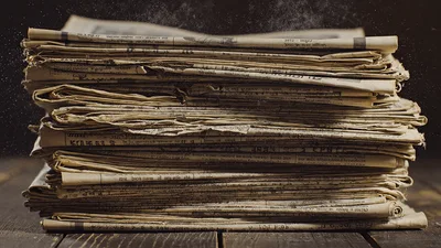 Stack Of Old Newspapers On A Wooden Table