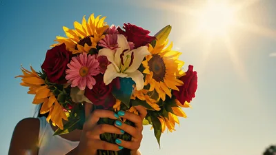 Woman Holding A Vibrant Bouquet Of Flowers Outdoors