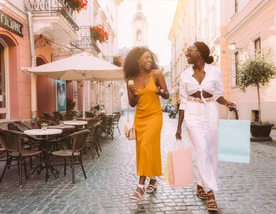 Two Women Walking and Shopping on a Cobblestone Street