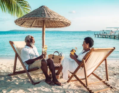 Senior Couple Enjoying Tropical Cocktails On Beach