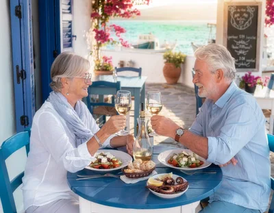 Senior Couple Toasting With Wine At Seaside Restaurant