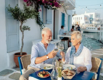 Senior Couple Toasting With Wine At A Greek Restaurant