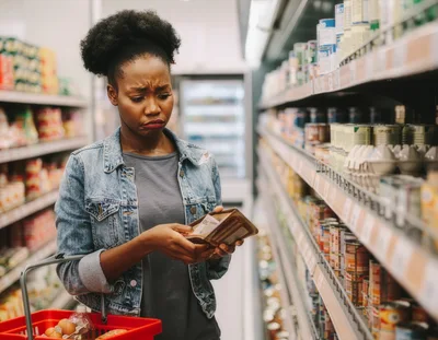 Stressed Woman Checking Wallet In Grocery Store
