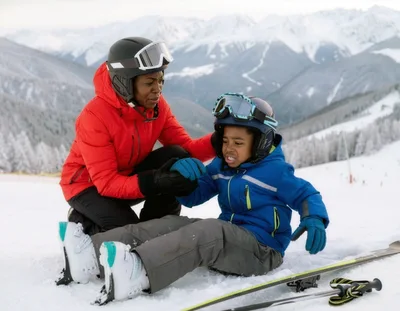 Mother Comforting Young Son After Skiing Fall