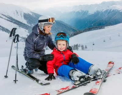 Mother Helping Young Son Learn To Ski