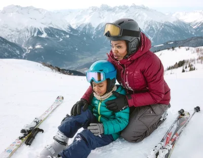Mother Comforting Young Son During Skiing Lesson