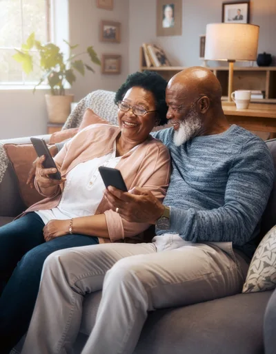 Senior Couple Using Smartphones Together on Sofa