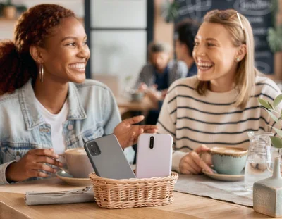 Two Happy Women Chatting Over Coffee in a Cafe