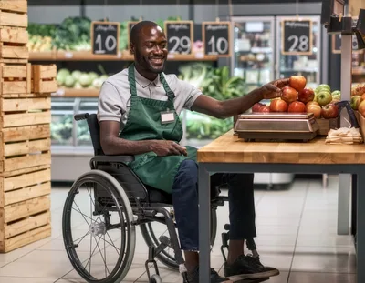 Grocery Store Employee In Wheelchair Weighing Apples