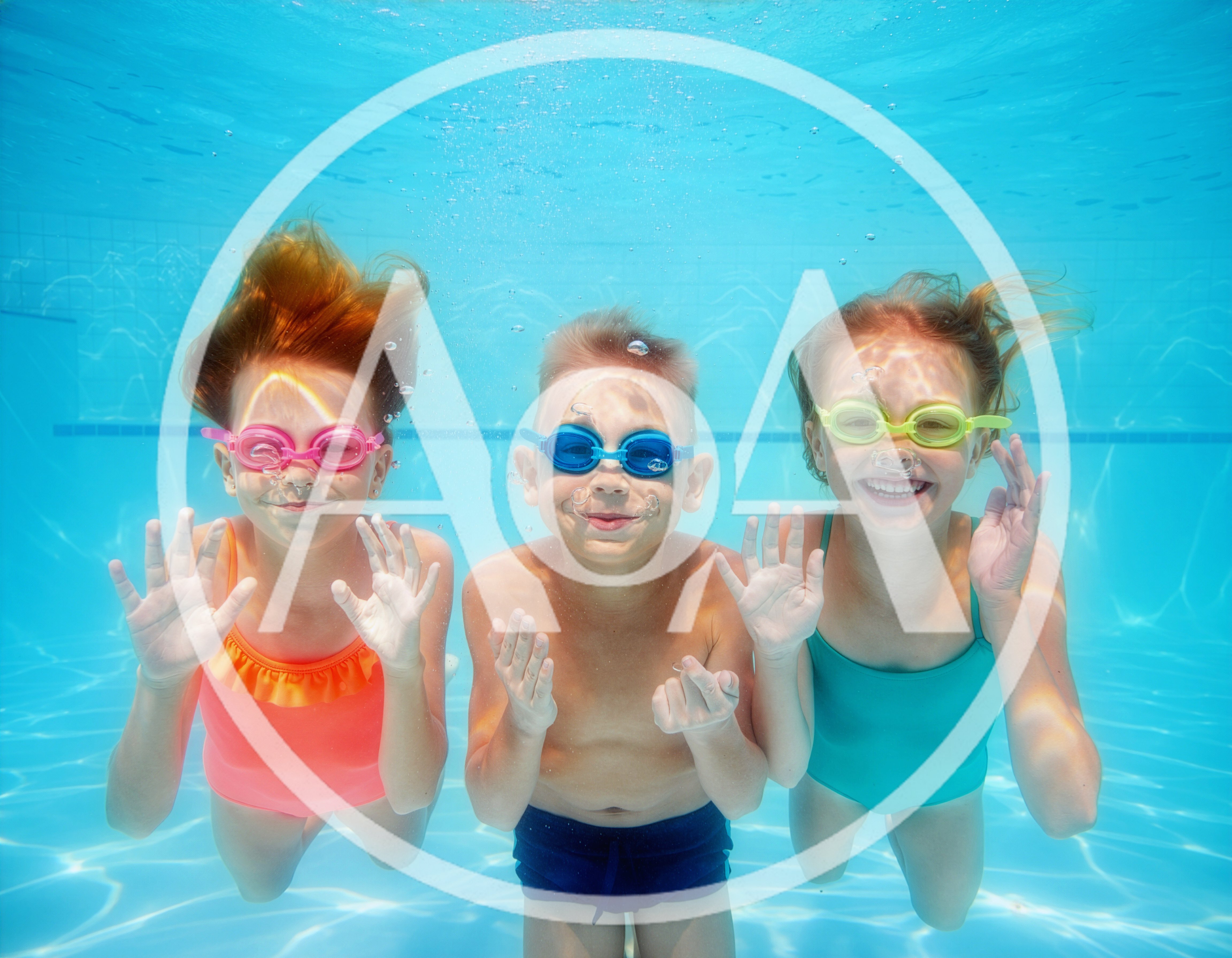 Three Children Swimming Underwater In A Pool