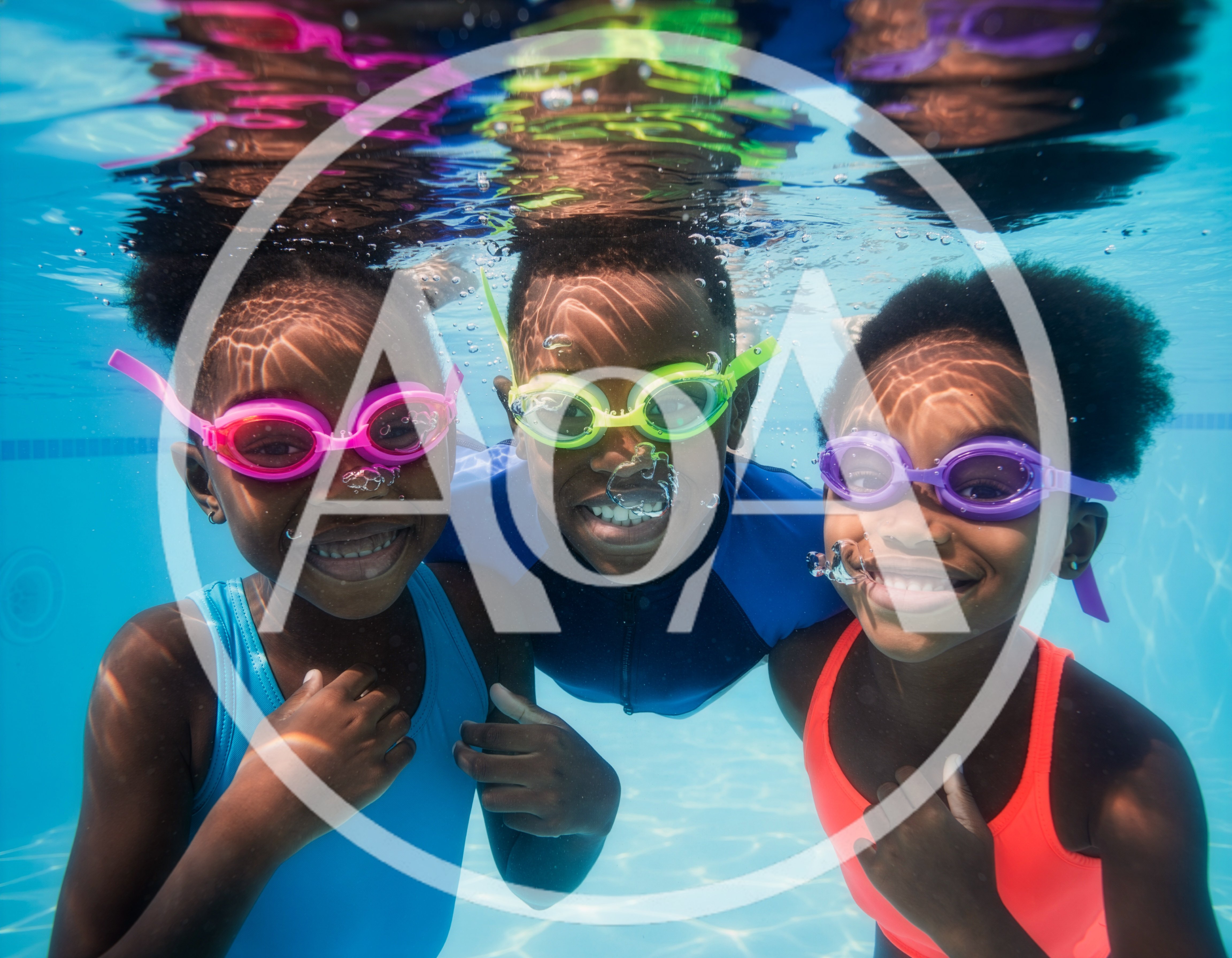 Three Children Swimming Underwater In A Pool