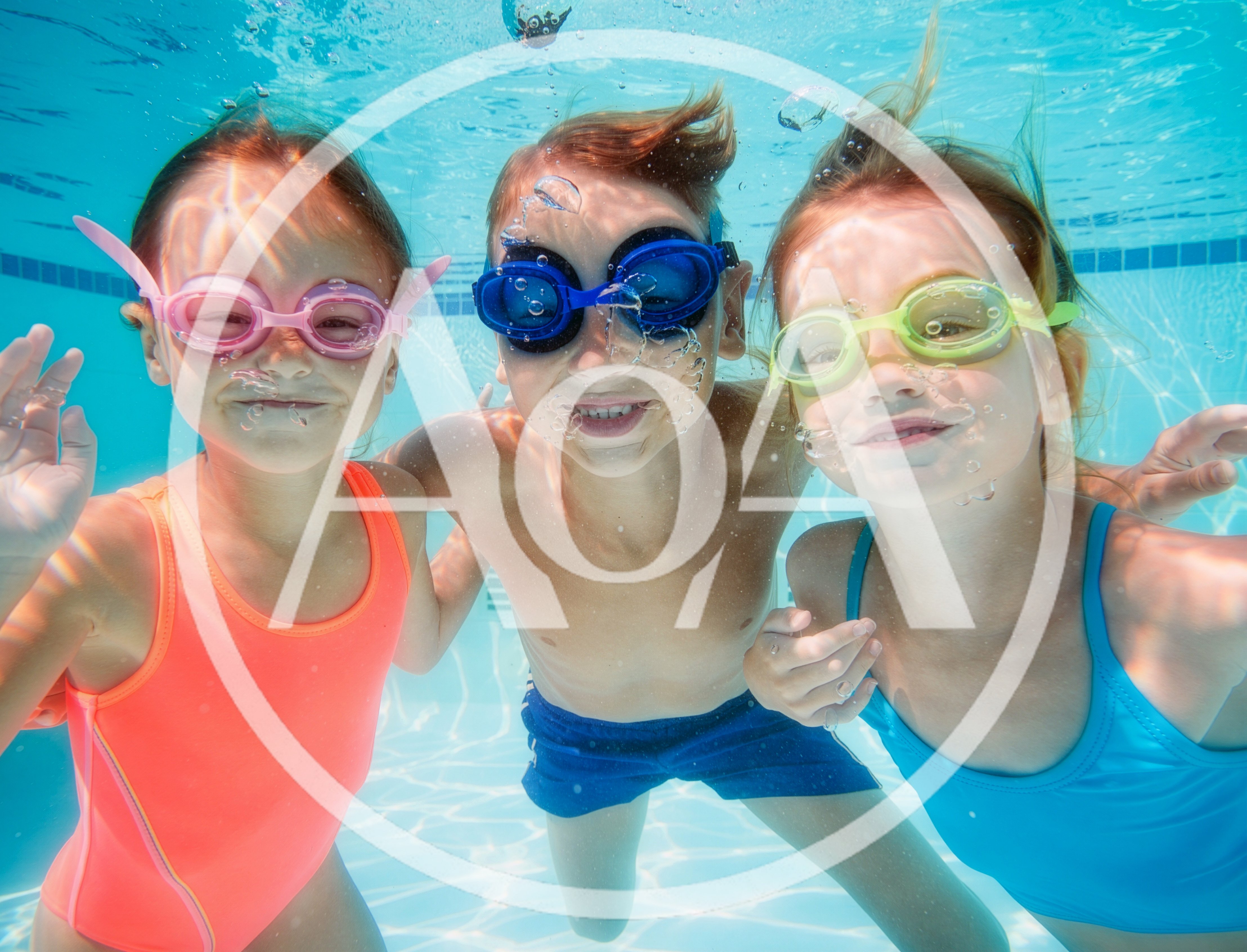 Three Children Swimming Underwater In A Pool