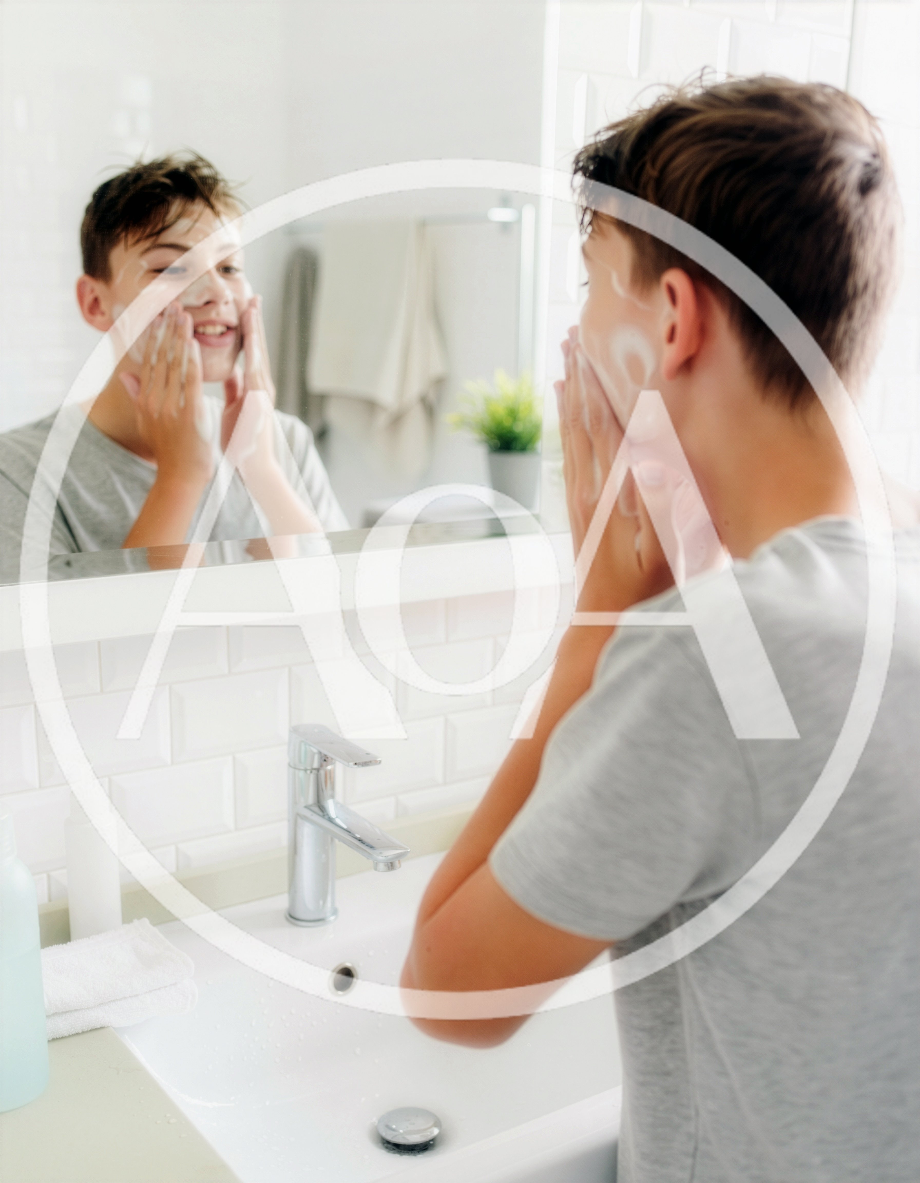 Teenage Boy Washing Face With Cleanser In Bathroom